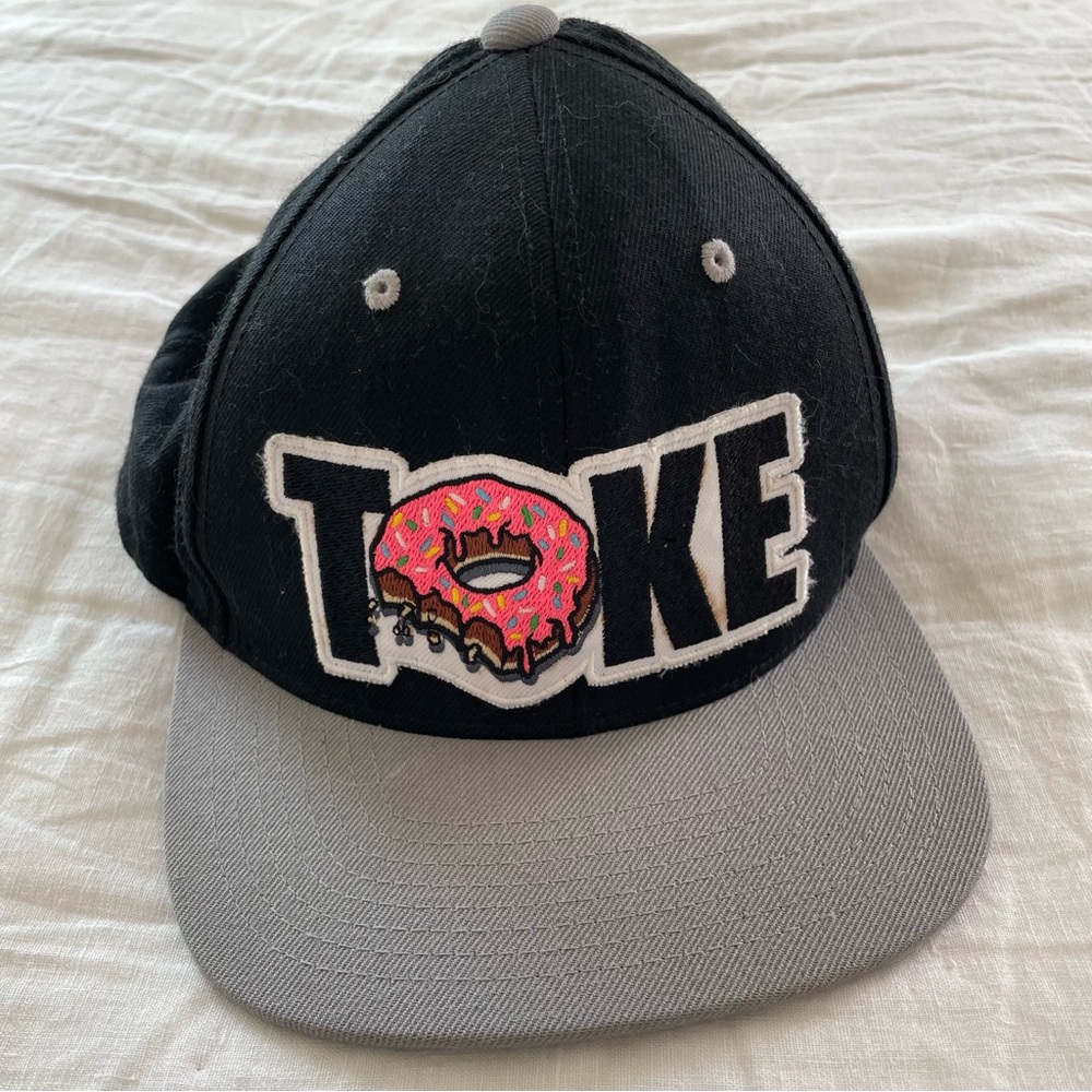 Black and grey Toke flat brim snap back hat with pink donut and green brim